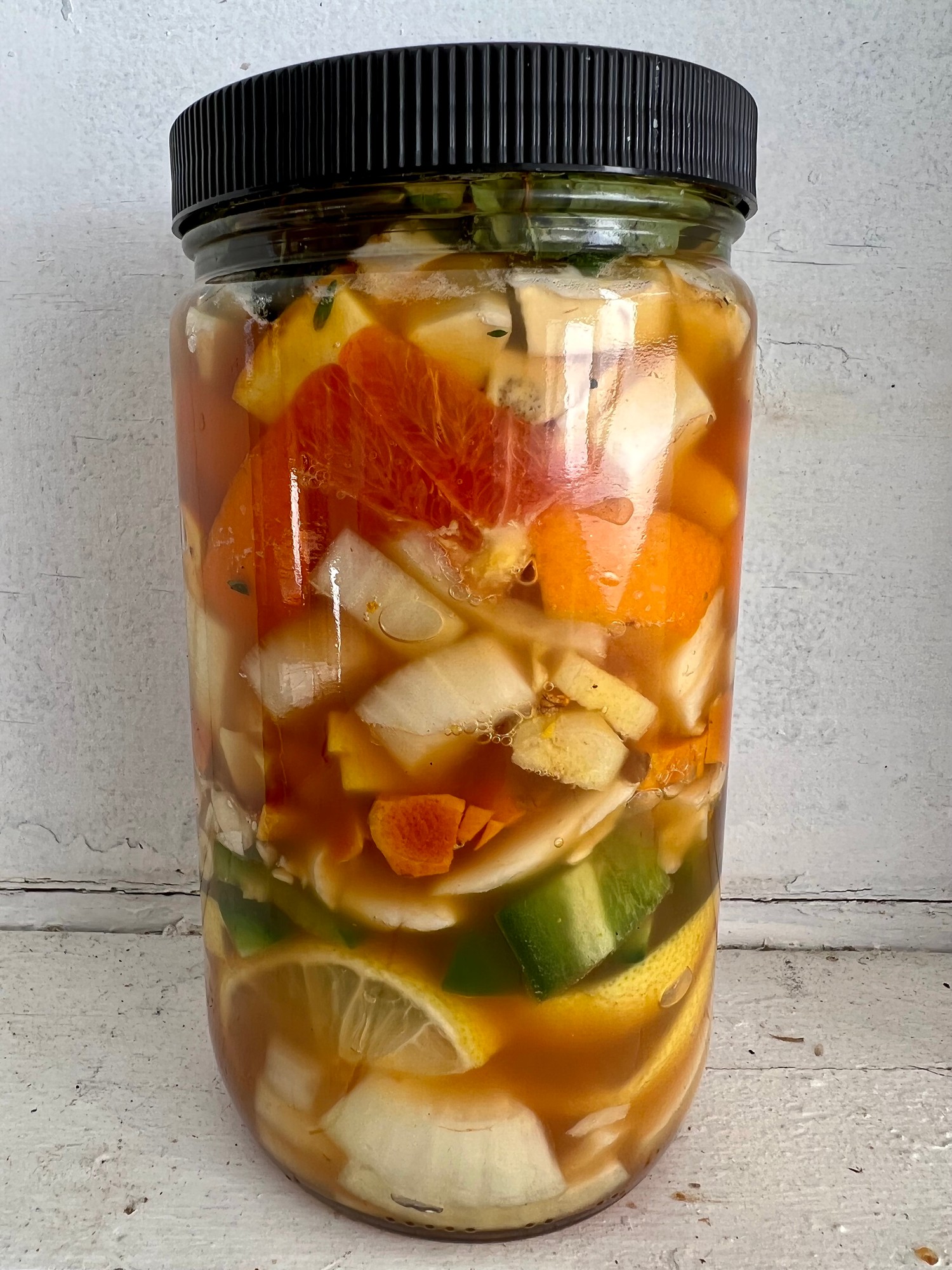 Fire Cider organic ingredients infusing in raw honey and organic apple cider vinegar